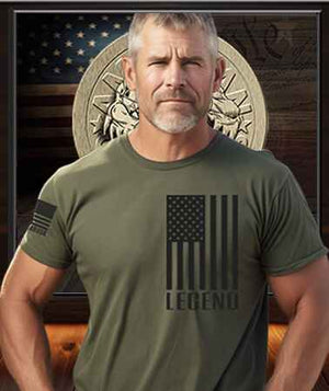 Patriot Gear USA Apparel Logo showcased in background of an American Patriot Man proudly wearing a shirt emblazoned with the text Legend, emphasizing the spirit of American patriotism and pride since 1776.